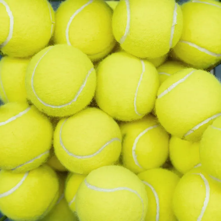 Close-up of a pile of bright yellow tennis balls