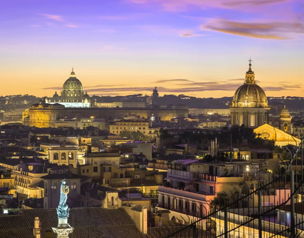 Evening view of Rome’s skyline with St. Peter’s Basilica and historic domes illuminated